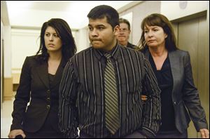 Erick Munoz, center, husband of Marlise Munoz is escorted by attorneys as he walks to 96th District Court on Friday in Fort Worth, Texas.  