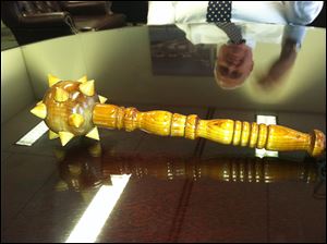 Chief of Staff Bob Reinbolt’s image is reflected in a tabletop holding a spiked, wooden mace. Mr. Reinbolt first found it eight years ago when he was working for Mayor Carty Finkbeiner.
