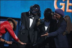Pharrell Williams, left, presents the award to Thomas Bangalter, second from left, and Guy-Manuel de Homem-Christo of Daft Punk, and Nile Rodgers for best pop duo/group performance for ‘Get Lucky.’