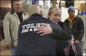 Jamie Armstrong hugs firefighter Jason Mercurio after she delivered food Saturday to Station 11. Behind her is her friend Kevin Nally and her son Shaun Wilson, 15.
