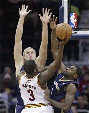 New Orleans Pelicans' Greg Stiemsma, left, and Tyreke Evans, right, block a shot by Cleveland Cavaliers' Dion Waiters (3) during the first quarter.