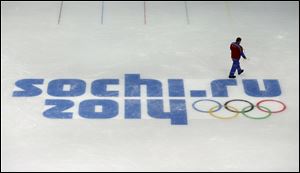 A worker leaves after checking ice conditions at the Iceberg Skating Palace, where the figure skating and short track speed skiing will take place, at the 2014 Winter Olympics Saturday in Sochi, Russia.