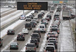 Traffic creeps along I-55 in north Jackson, Miss., today as ice and snow flurries cause difficult driving conditions.