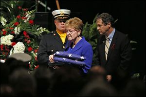U.S. Rep. Marcy Kaptur and U.S. Sen. Sherrod Brown move forward to present American flags to the firefighters’ families. 