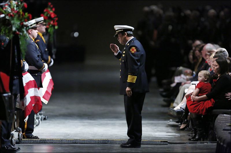 Toledo Fire Chief Luis Santiago salutes the casket of James Dickman