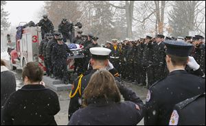 Firefighters salute as the casket holding Toledo firefighter Private James Dickman arrives at Oakland Cemetery in Sandusky after a funeral service that drew more than 700 to The Chapel on Galloway Road near Sandusky.