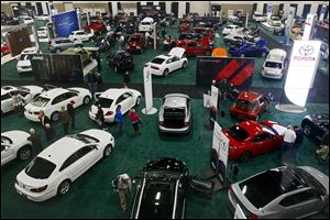 Auto enthusiasts look over the vehicles at last year’s Toledo Auto Show. This year’s show is again at SeaGate Convention Centre.