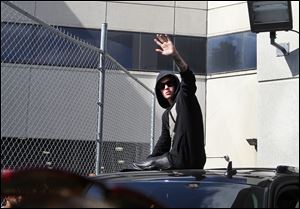 Singer Justin Bieber waves from atop an SUV as he leaves the Turner Guilford Knight Correctional Center, in Miami, last week.