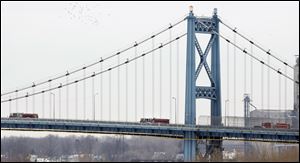 Firetrucks make their way over the Anthony Wayne Bridge in Toledo during the funeral procession for Toledo firefighter James Dickman.