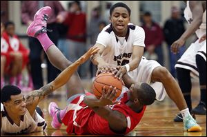 Scott’s Chris Harris, left, and Chris Darrington, top, battle  Bowsher’s Nate Allen for a loose ball. Harris finished with 35 points.