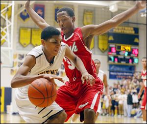 Whitmer’s D.J. Triplett drives against Central Catholic’s Montrese Marshall on Friday night. Triplett, a freshman, scored six points for the Panthers.