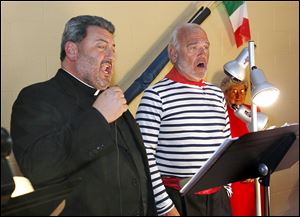 The Rev. Msgr. Michael Billian, left, pastor of Most Blessed Sacrament Church, sings with David Herring. The choir, along with St. Rose Parish, is to perform at the Vatican next Christmastime.