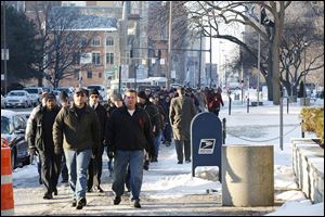 Toledo firefighters walk to the courthouse from International Association of Fire Fighters Local 92 union hall for the arraignment of Ray Abou-Arab, 61, the owner of the apartment building where two firefighters died. 