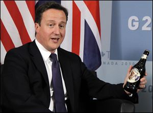 British Prime Minister David Cameron holds a bottle of Hobgoblin