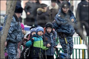 Police officers evacuate children from a Moscow school early today.