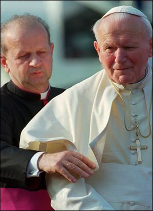 Pope John Paul II, right, is helped by his personal secretary, Stanislaw Dziwisz, as he arrives in Como, northern Italy, in May, 1996.