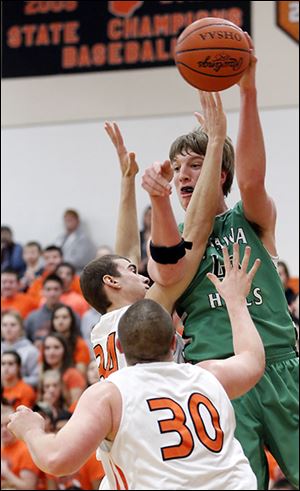 Ottawa Hills’ R.J. Coil passes the ball against Gibsonburg’s Andy Burmeister, center, and Andrew Cantrell. Coil scored 20 points.
