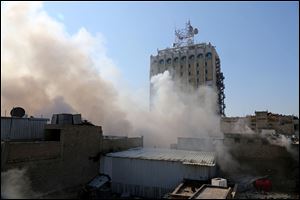 Smoke rises after a parked car bomb went off at a commercial center in Khilani Square in central Baghdad, Iraq, today.