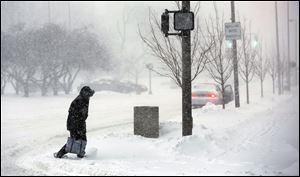 A pedestrian crosses Jackson Street at North Huron Street on Wednesday during the height of the snowfall. Officially, 8.4 inches of snow fell, but near the Valentine Theatre, 10 inches were measured.
