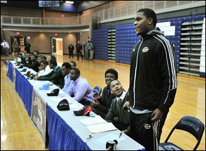 Teammates and schoolmates react after Malik McDowell, right, announces he will be attending Michigan State University to play football during a national signing day ceremony at Southfield High School's gym in Southfield, Mich.