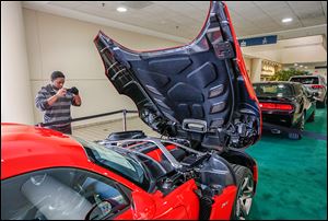 James Watkins, 16, of Toledo photographs a Dodge Viper on the opening day of the auto show. 