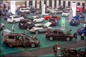 People check out the new models on display at the 2014 Greater Toledo Auto Show on Thursday. There are  25 brands, 126 ve­hi­cles, and 14 mo­tor­cy­cles to investigate. 