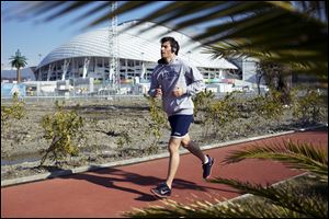 A man runs at a boardwalk near the Fisht Olympic Stadium in Olympic Park today in Sochi, Russia.
