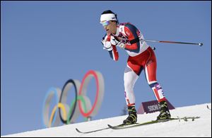 Norway's gold medal winner Marit Bjoergen skis past the Olympic rings during the women's cross-country 15k skiathlon Saturday Krasnaya Polyana, Russia.