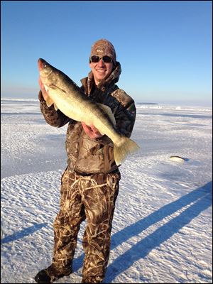 Jon Pollauf holds a walleye he caught through the ice on a recent trip out on Lake Erie. Pollauf said he has encountered ice 12-14 inches thick several miles out on the lake.