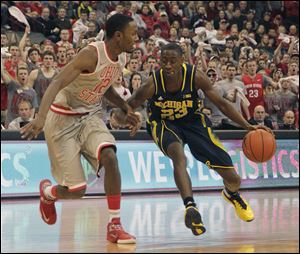 Michigan's Caris LeVert, right, drives the lane as Ohio State's Sam Thompson defends.