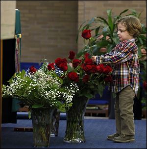 Dylan Breininger puts a rose in a vase during a special procession at St. Joseph Parish marking the anniversary of the Roe vs. Wade decision.