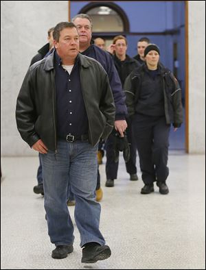 Toledo Fire Department personnel including Jeff Romstadt, president of Toledo Firefighters Local 92, front, walk to the courtroom Tuesday before the arraignment of Ray Abou-Arab.