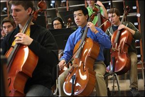 Starr Jiang, 15, center, plays the cello during orchestra practice at Northview High School. 