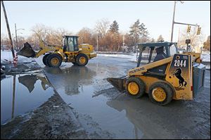 Water and ice are cleared from the Anthony Wayne Trail near Glendale after a water-main break. 