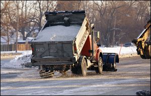 Salt is spread on the Anthony Wayne Trail near Glendale Avenue in Toledo following a water main break.  Northbound lanes in the area were closed to traffic as a result of the incident early Thursday. 