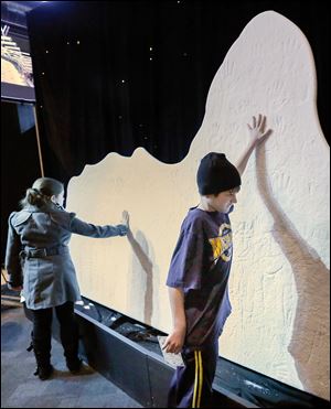 Bronson Ulery, 12, of Sylvania gets hands-on with a mini iceberg replica that was cool — both figuratively and literally — as he toured ‘Titanic: The Artifact Exhibition’ at the Imagination Station. 