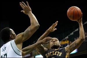 Toledo's Rian Pearson (5) goes in for a layup under pressure from Eastern Michigan's Da'Shonte Riley (10) during the first half.