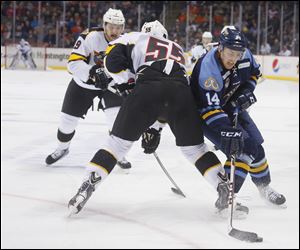 Toledo Walleye player Joe Gleason (14) beats Cincinnati Cyclones player Byron Froese (55) to the puck during the second period.