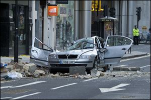 A smashed up car is seen in Kingsway opposite Holborn Tube station in central London, after a woman was killed when large chunks of masonry fell onto a Skoda Octavia vehicle she was in.