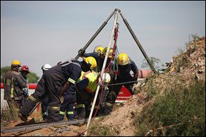 Workers attempt to free trapped illegal miners at a gold mine near Benoni, on the outskirts of Johannesburg. Many fear leaving the mine because they face arrest. Illegal mining is an issue in the country, a major producer of gold and platinum.