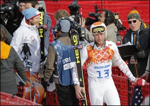 Gold medal winner Norway's Kjetil Jansrud, left, is interviewed in the finish area as joint bronze medal winner Bode Miller walks away in tears after his television interview Sunday.