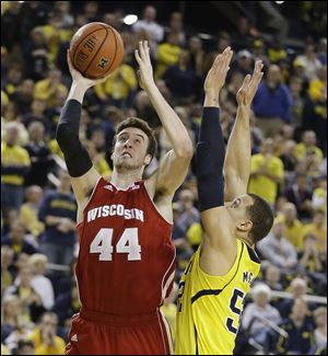 Wisconsin’s Frank Kaminsky goes around Michigan’s Jordan Morgan for a shot during the second half. Kaminsky scored seven points in a decisive run for the Badgers and finished with 25.