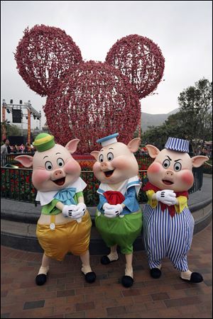 Disney's Three Little Pigs pose in front of a cherry blossom Mickey Mouse at Hong Kong Disneyland.