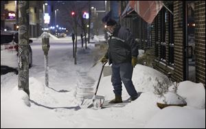 Downtown Toledo resident and business owner Paul Sullivan gets an early start shoveling the sidewalk in front of his architecture office on South St. Clair Street.