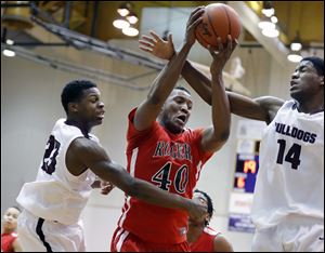 Rogers' Fadil Robinson (40) pulls in a rebound against Scott's Trey Brown (23) and Percy Bogan (14).