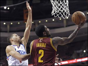 Cleveland Cavaliers' Kyrie Irving (2) drives to the basket as Philadelphia 76ers' Michael Carter-Williams defends.