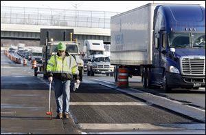 Ohio Department of Transportation official Dave Kanavel prepares to fix potholes on I-75 north of the I-475 split in Toledo. Parts of I-75 and I-475 will be closed today so crews can repair potholes.