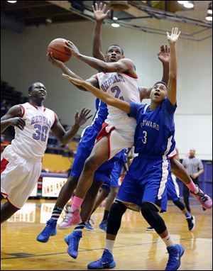 Bowsher's Aundre Kizer (2) goes to the basket against Woodward's Breon Strozier (3).