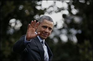 President Barack Obama waves to reporters as he walks on the South Lawn of the White House in Washington today.