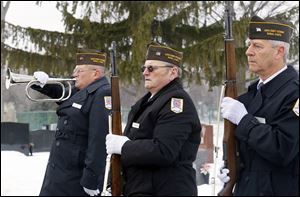 Joe Soinski  plays the bugle while Rob Greenlese and Larry Hall, right,  fellow members of the Lucas County Veterans Burial Corps, stand at attention during the funeral of Navy veteran Joseph John Patay on Wednesday at Mount Carmel Cemetery in Toledo. 